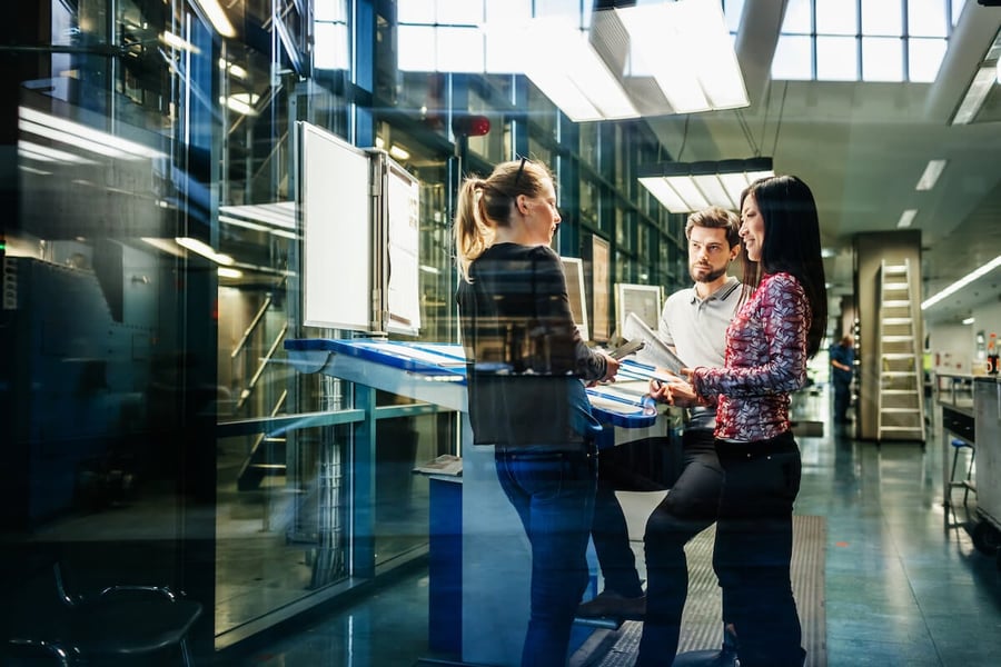 A team of engineers having a discussion at a desk in a factory