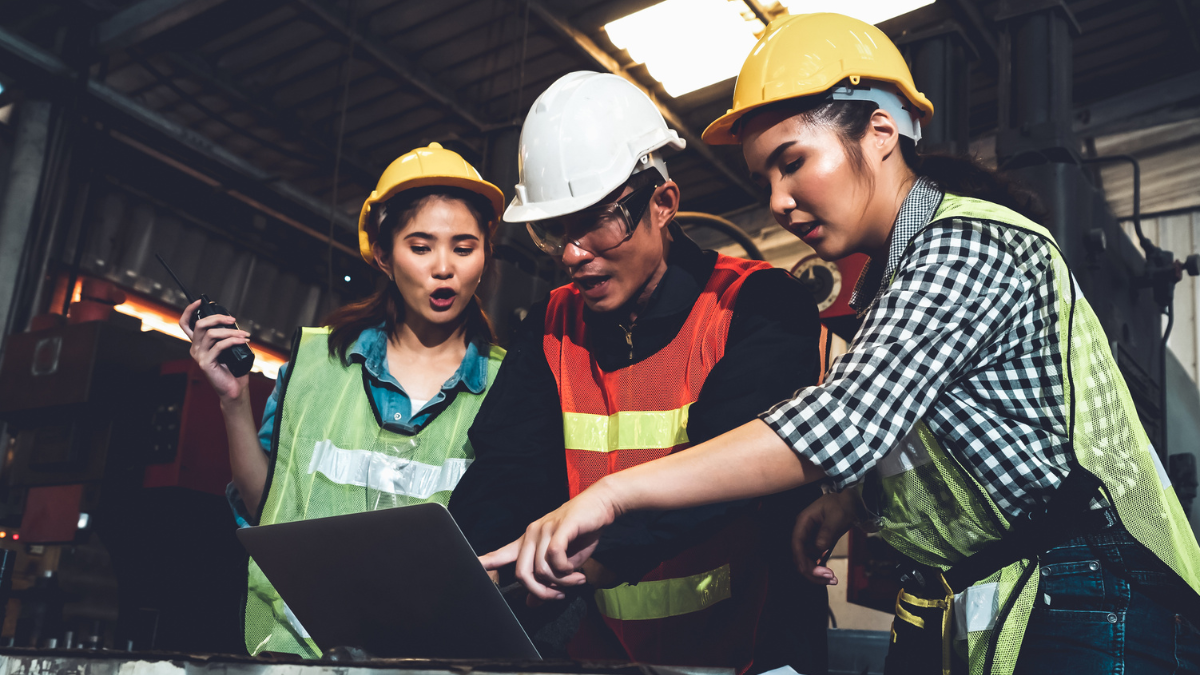 a product engineering team reviewing tolerance analysis training documents on a laptop