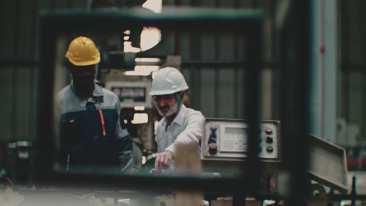 2 workers in a manufacturing facility discussing the importance of variation management