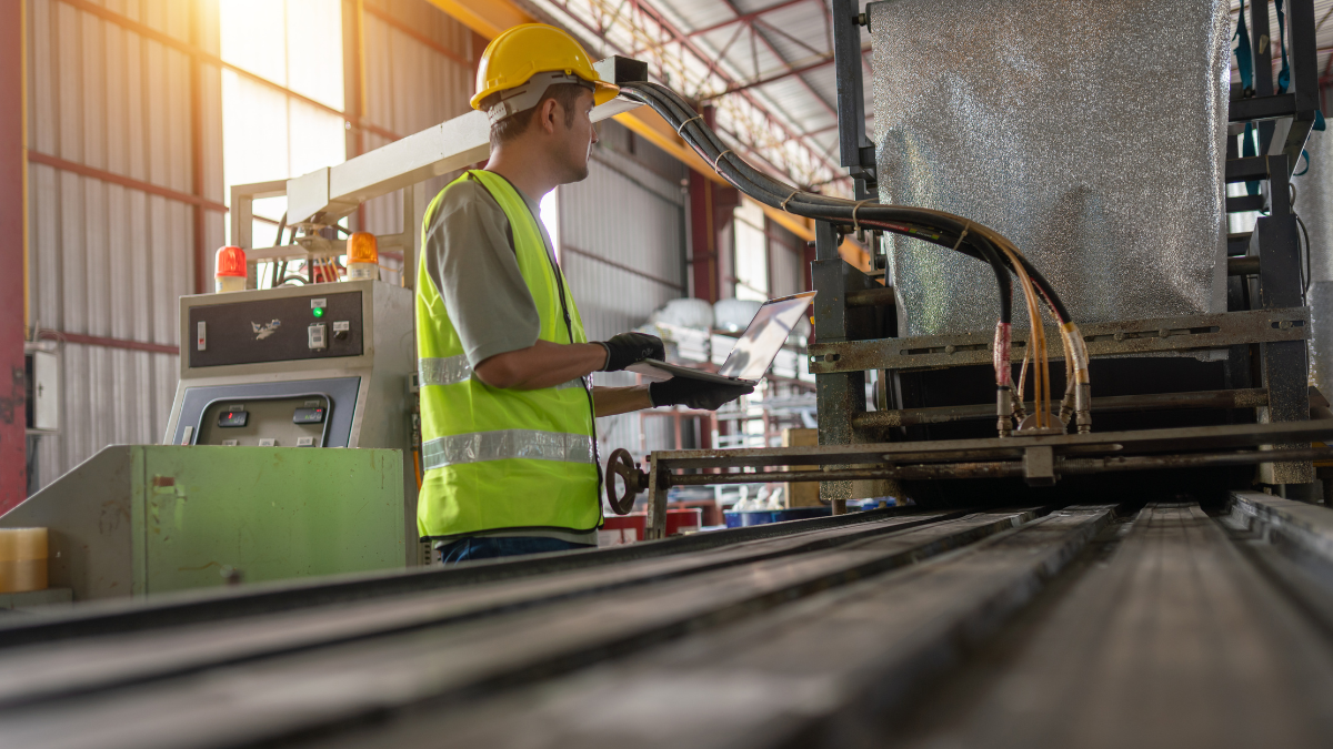 a person in a manufacturing facility using their laptop to research how variation management improves product consistency